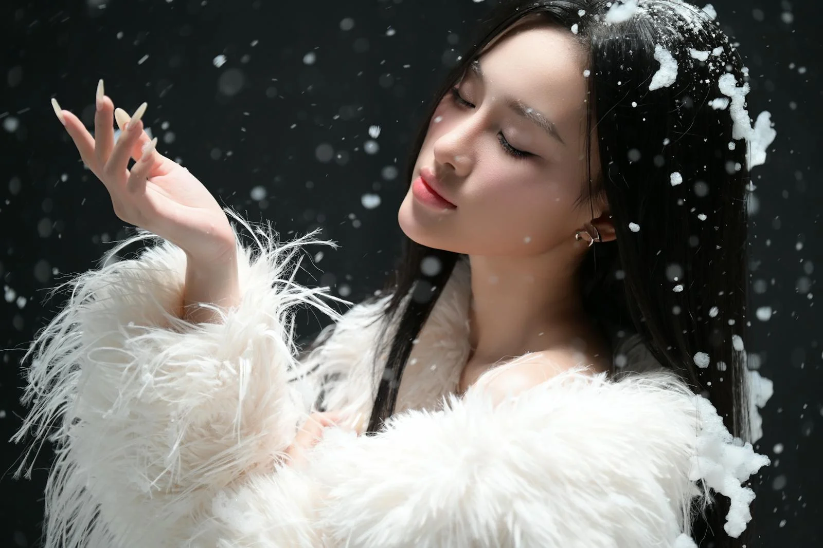 Stunning portrait of a woman in a white coat with snowflakes, capturing winter elegance.
