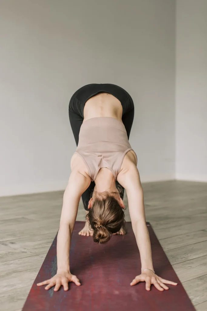 Woman practicing yoga indoors with focus on flexibility and wellness.