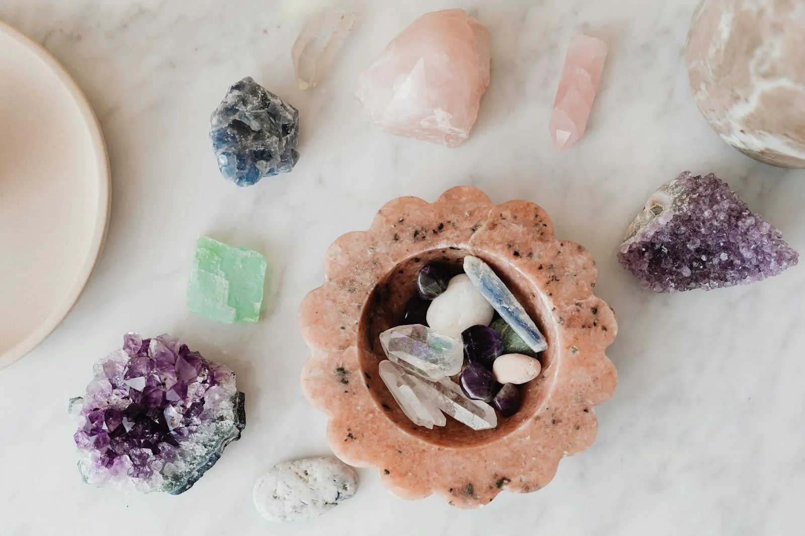 A diverse assortment of healing crystals and stones arranged on a marble surface, ideal for spirituality and wellness themes.