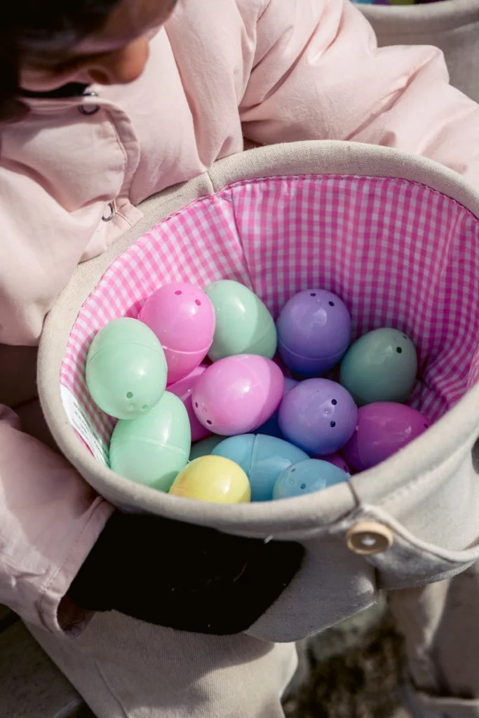 A child holding a basket filled with vibrant Easter eggs, symbolizing festive joy.