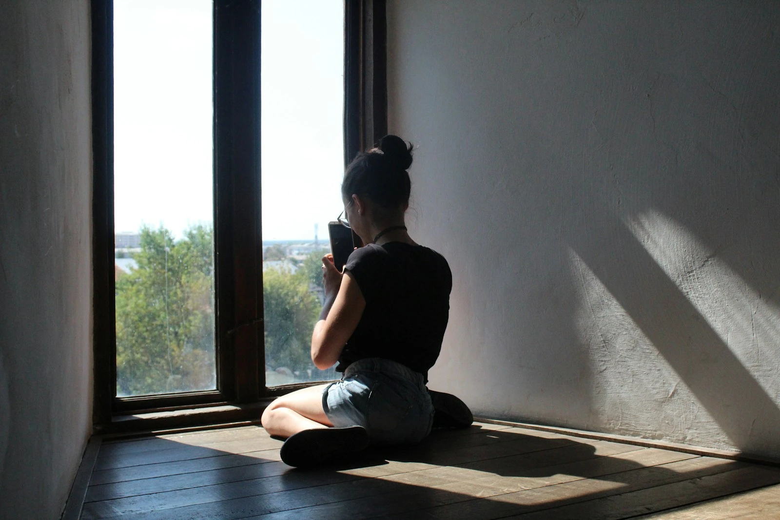 woman sits near the glass window