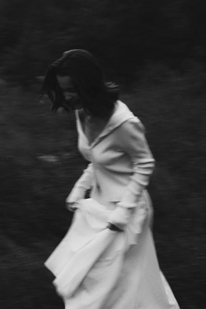 A captivating black and white image of a woman in motion in a mysterious setting.