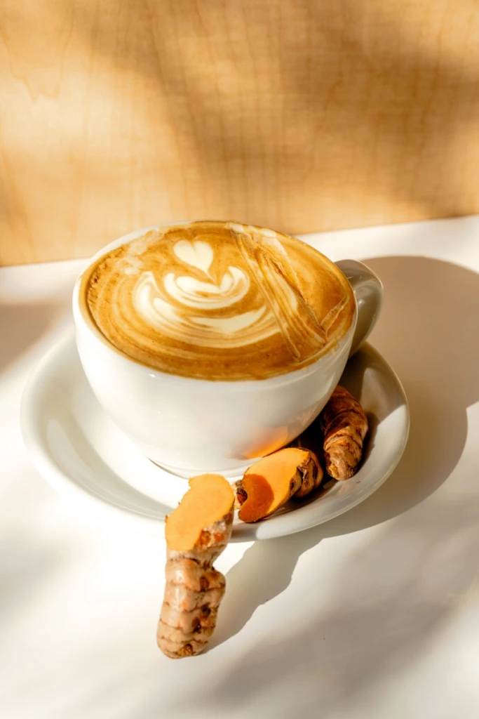 A cappuccino on a saucer with cinnamons on a saucer