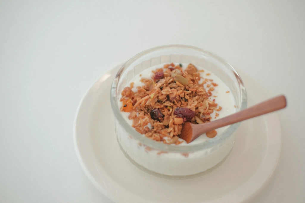 A bowl of cereal and a spoon on a plate