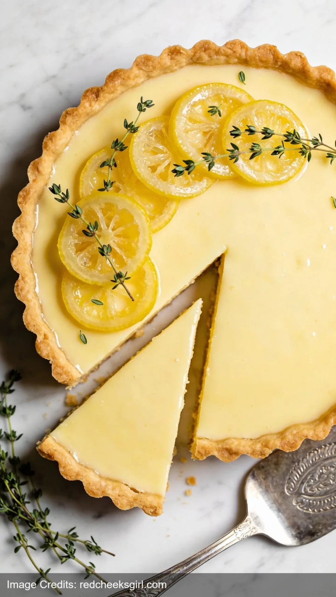 lemon tart with olive oil crust on marble surface with candied lemon garnish