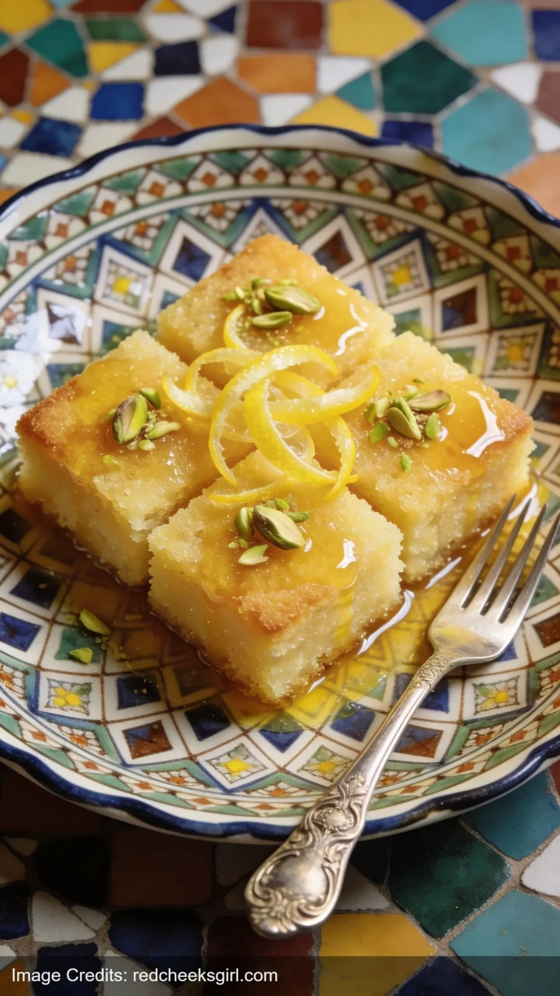 lemon semolina revani cake squares with syrup on decorative ceramic plate with pistachios