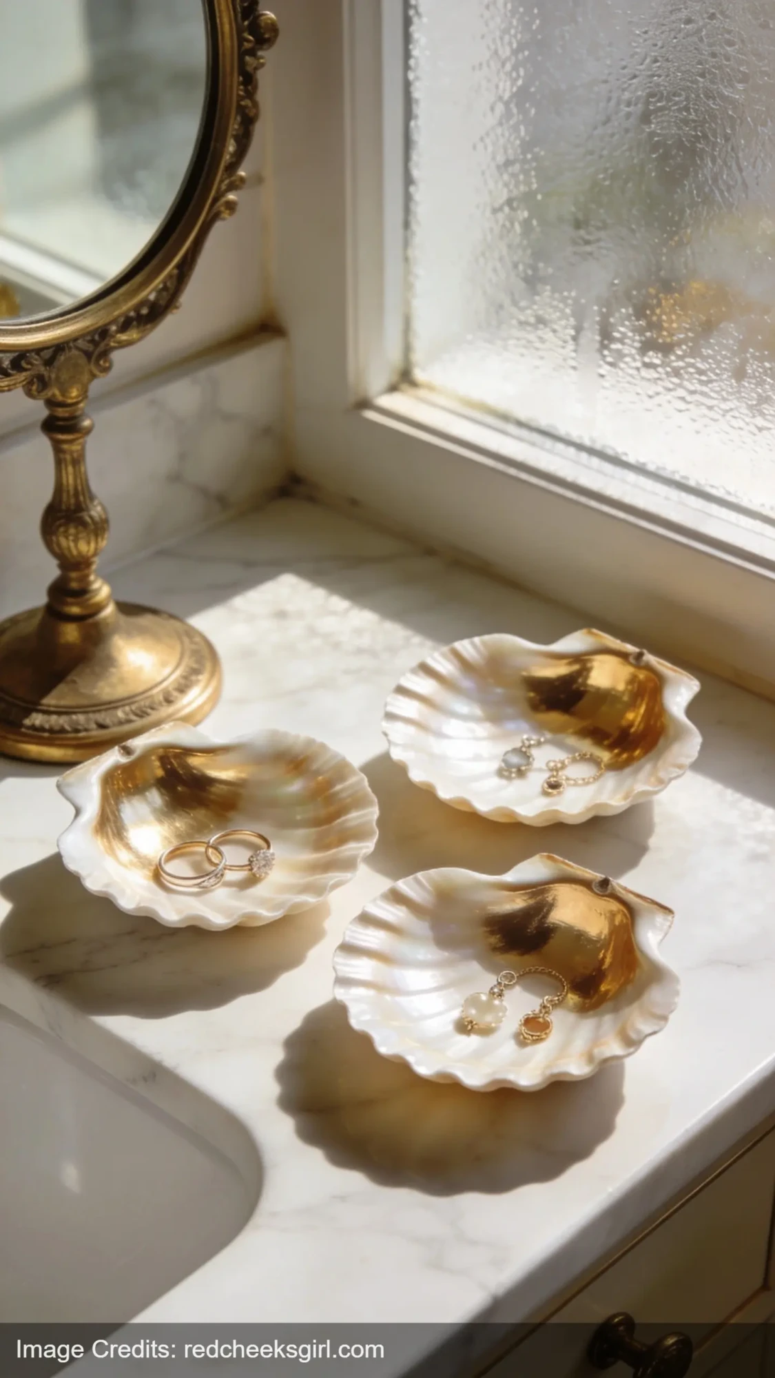 DIY gold painted scallop shell jewelry dishes on marble vanity for coastal home decor