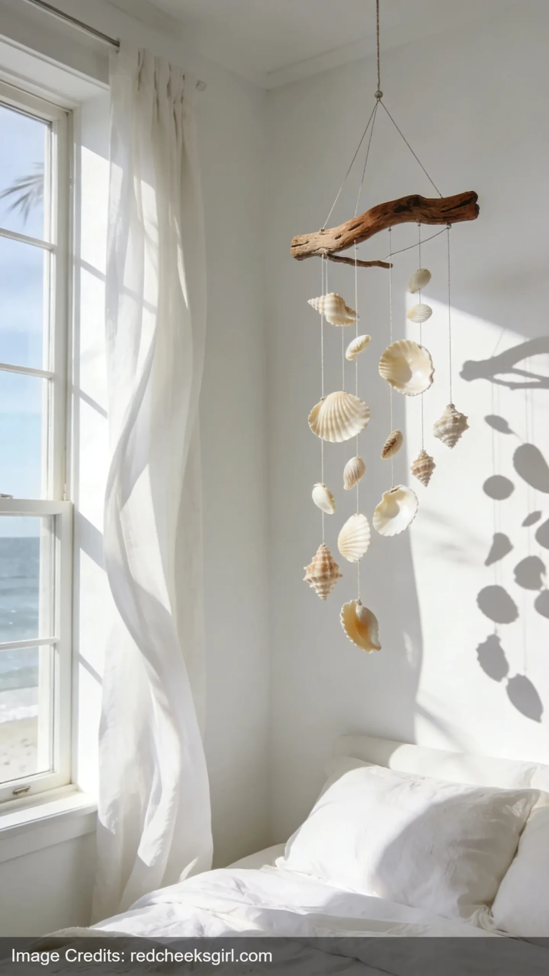 DIY driftwood and seashell mobile hanging in bright coastal bedroom for natural decor