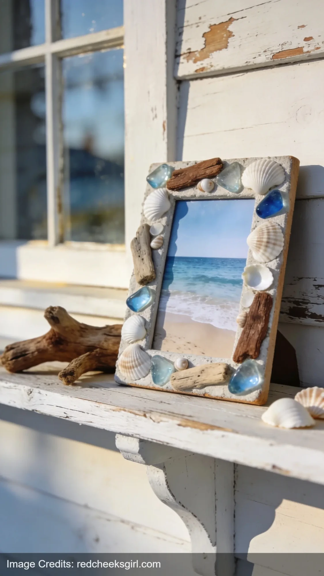 handmade driftwood photo frame decorated with shells and sea glass displaying beach photo