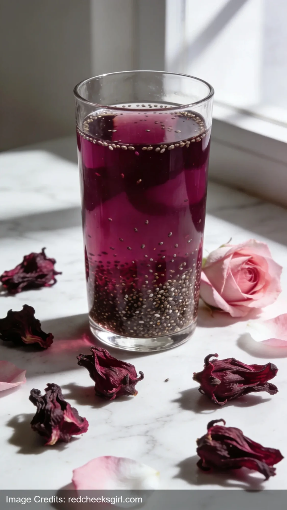 hibiscus chia water in glass with dried flowers on marble surface