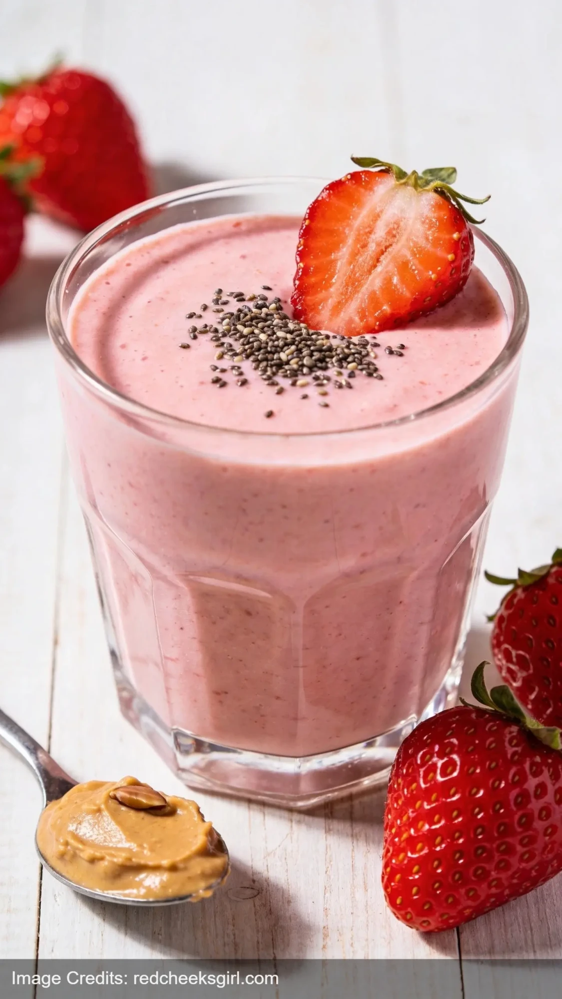 thick creamy strawberry protein smoothie with almond butter and fresh strawberry garnish