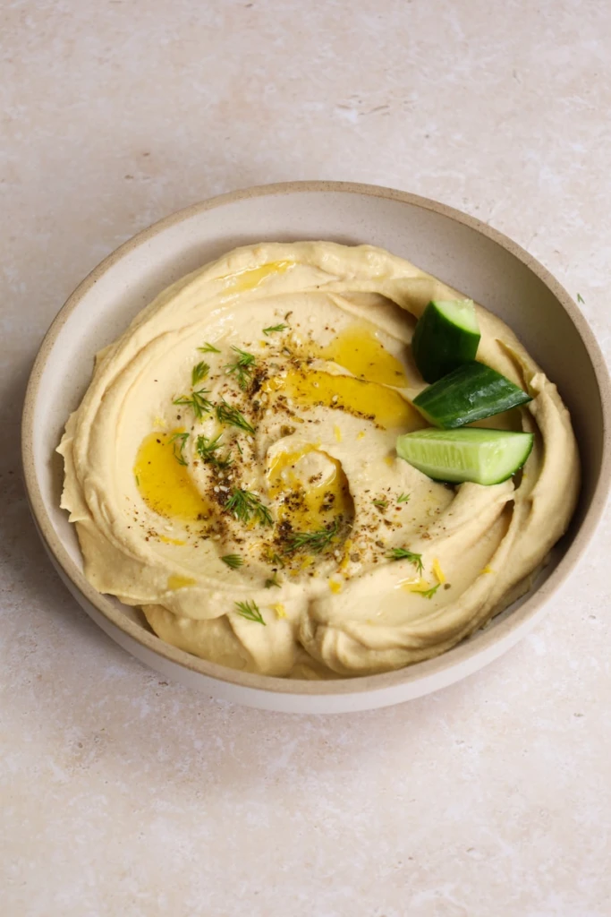 Creamy hummus with olive oil and cucumber.