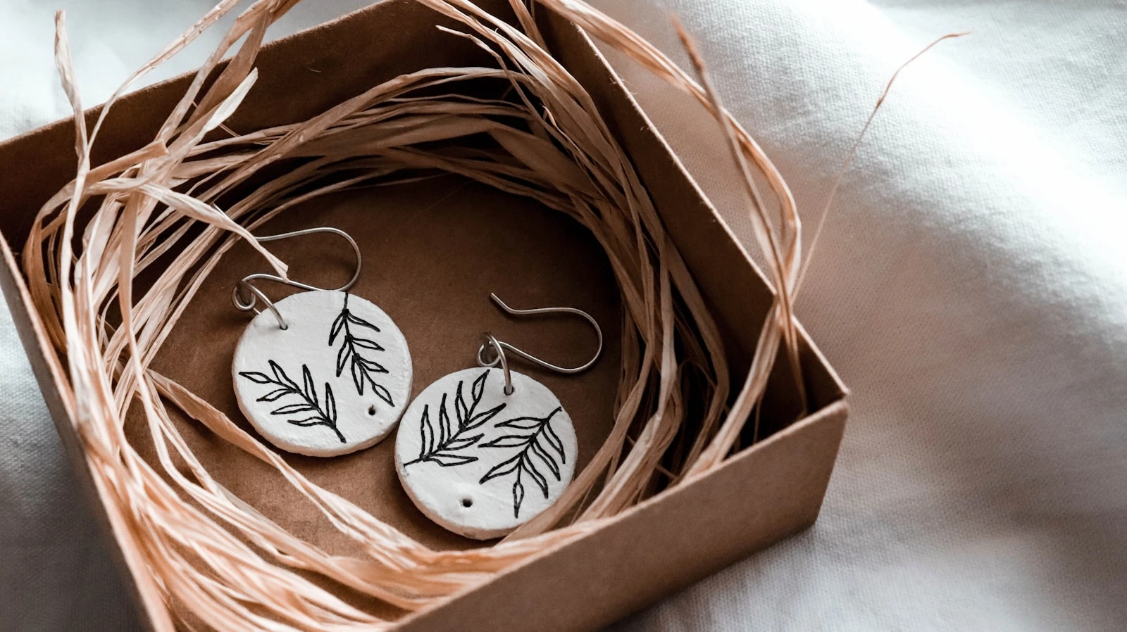 white and black floral round ornament in brown cardboard box
