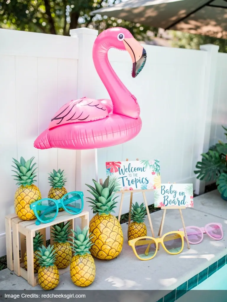 Pool party baby shower photo prop corner with flamingo inflatable and tropical themed photo props