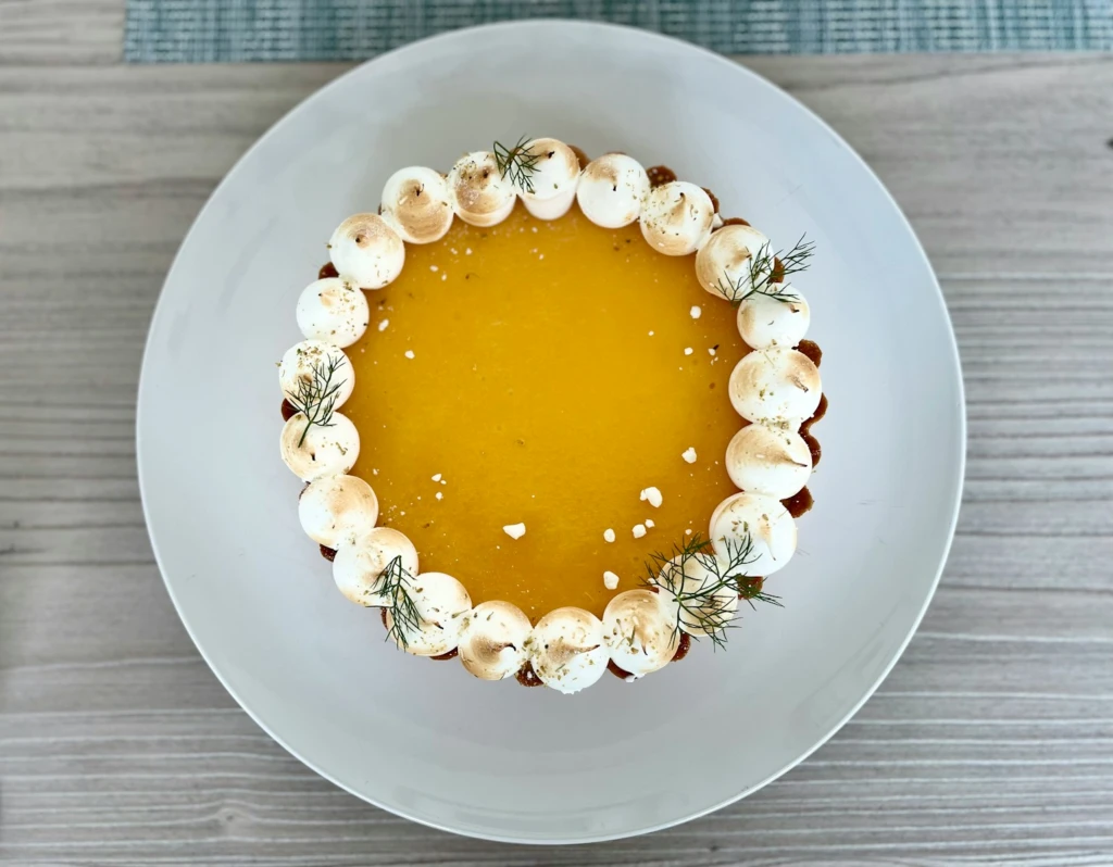 a white plate topped with a dessert covered in whipped cream