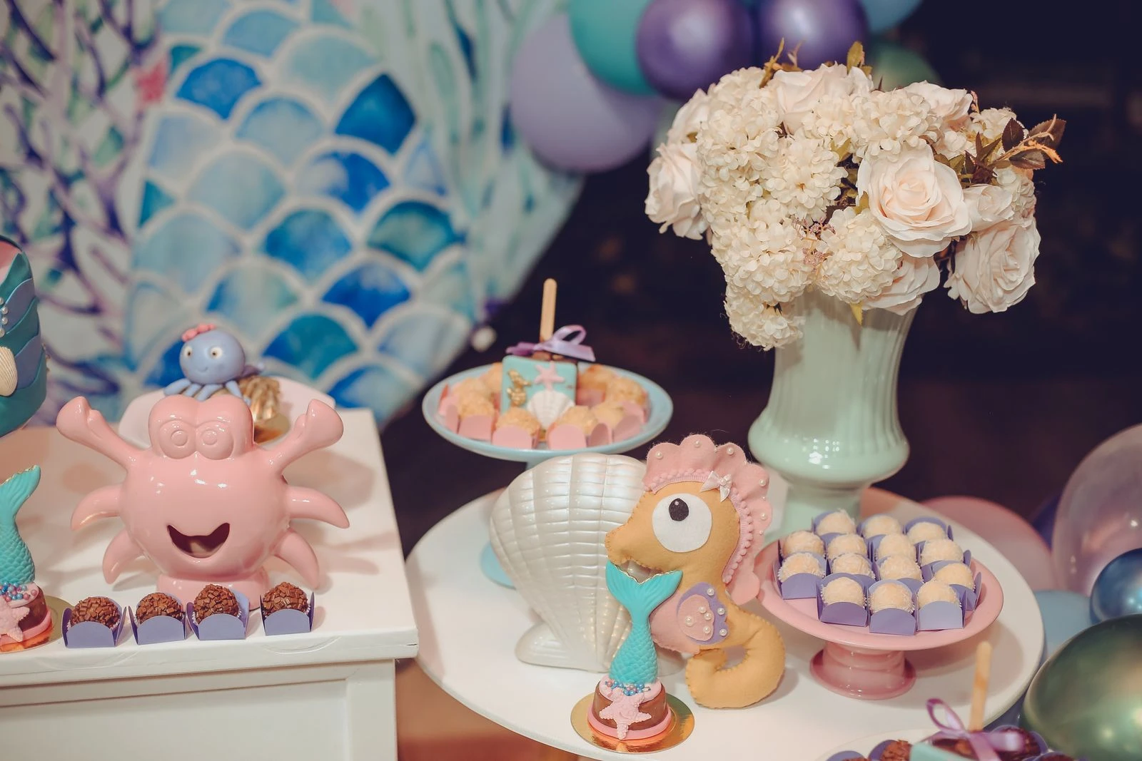 Vibrant under the sea themed dessert table with ocean-inspired decorations and sweet treats.