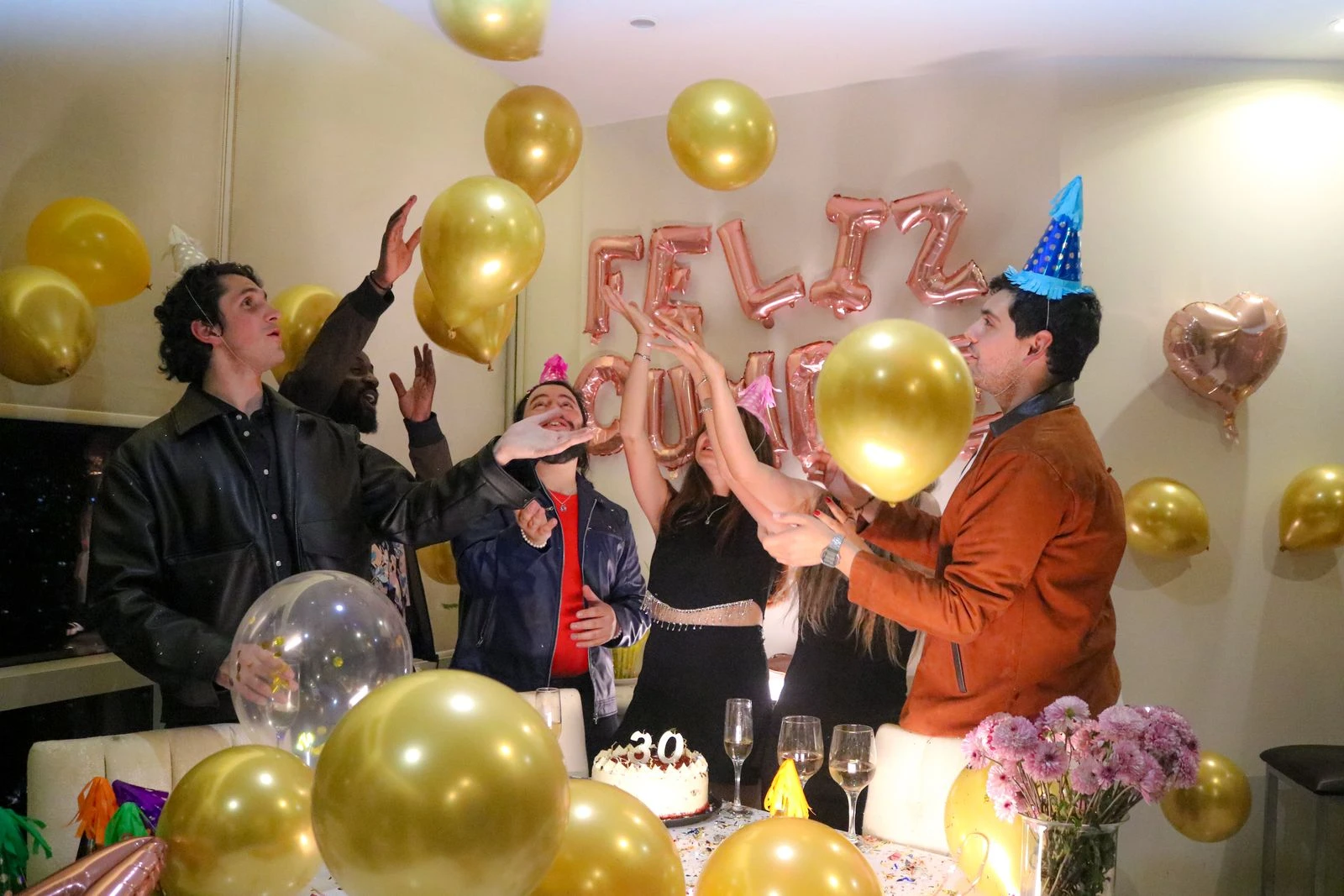 A lively indoor New Year's Eve party celebration with balloons and friends.