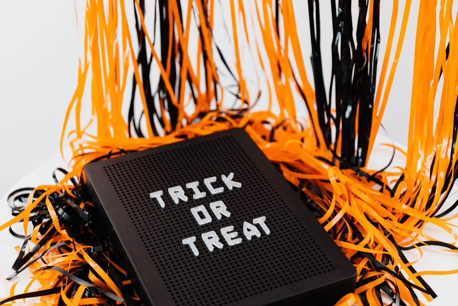 A festive Halloween sign displaying 'Trick or Treat' surrounded by orange and black ribbons.