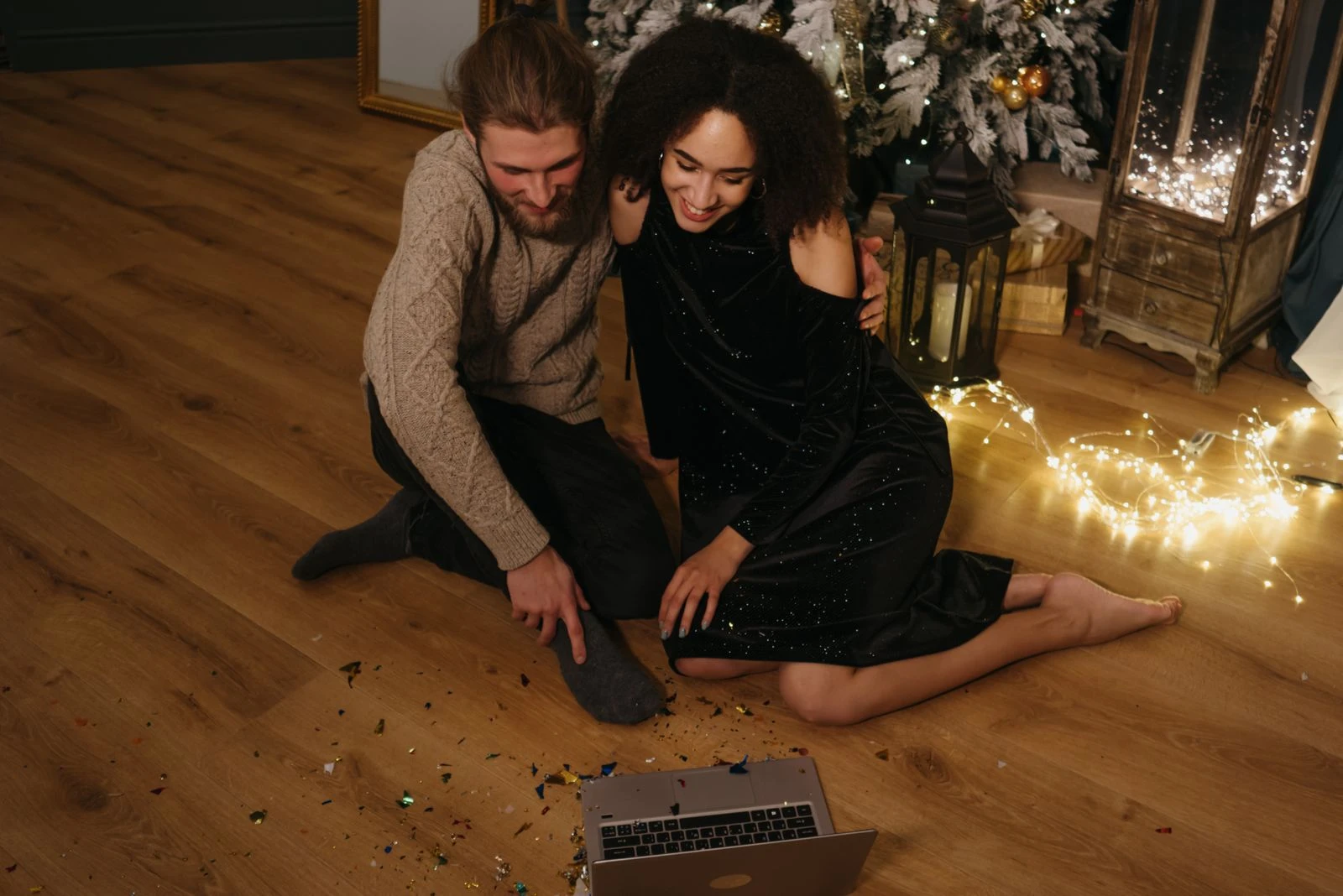 A couple enjoying a festive video call celebration with Christmas decorations.