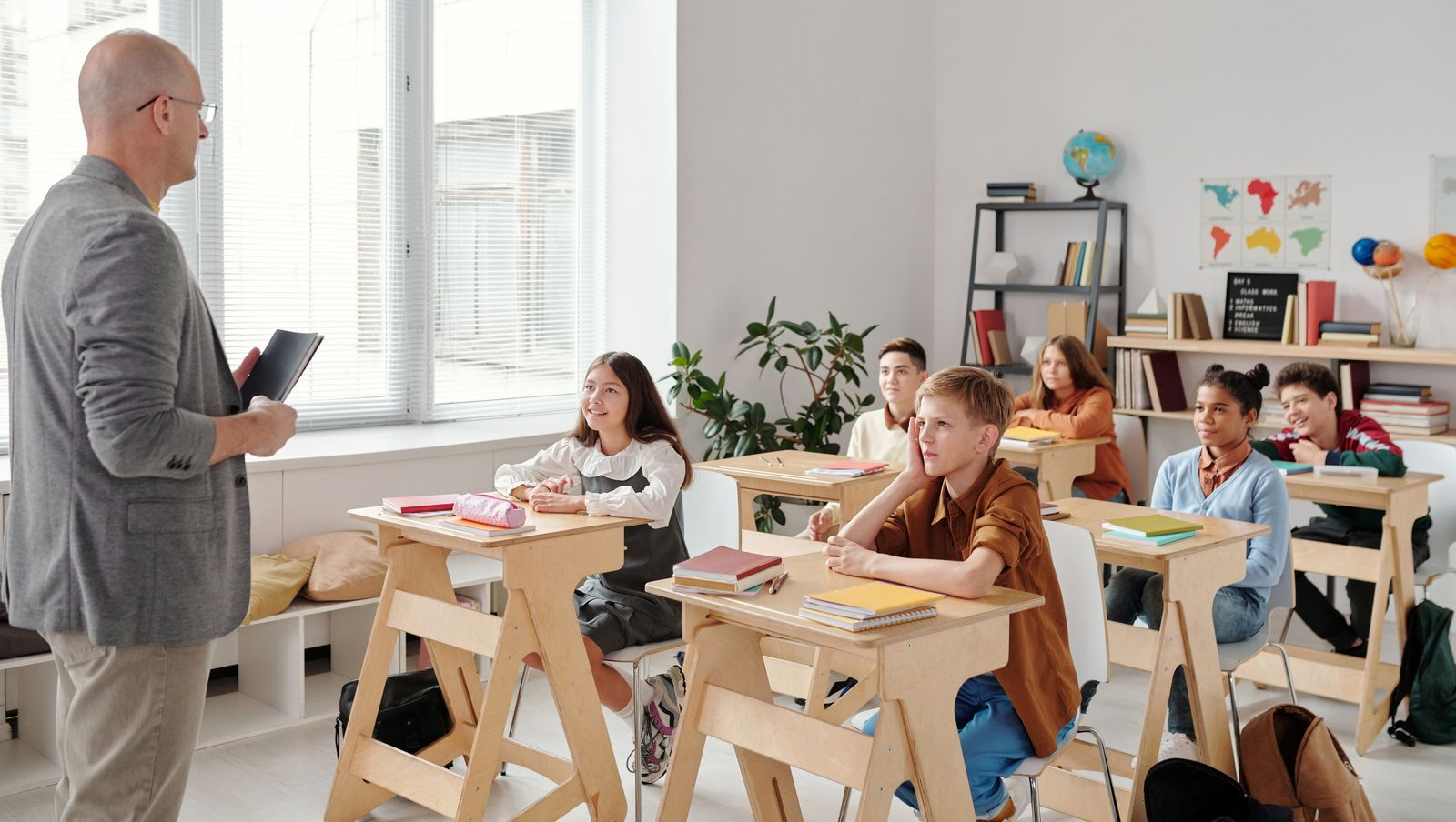 A teacher conducting a lesson in a diverse, engaging classroom with attentive students.