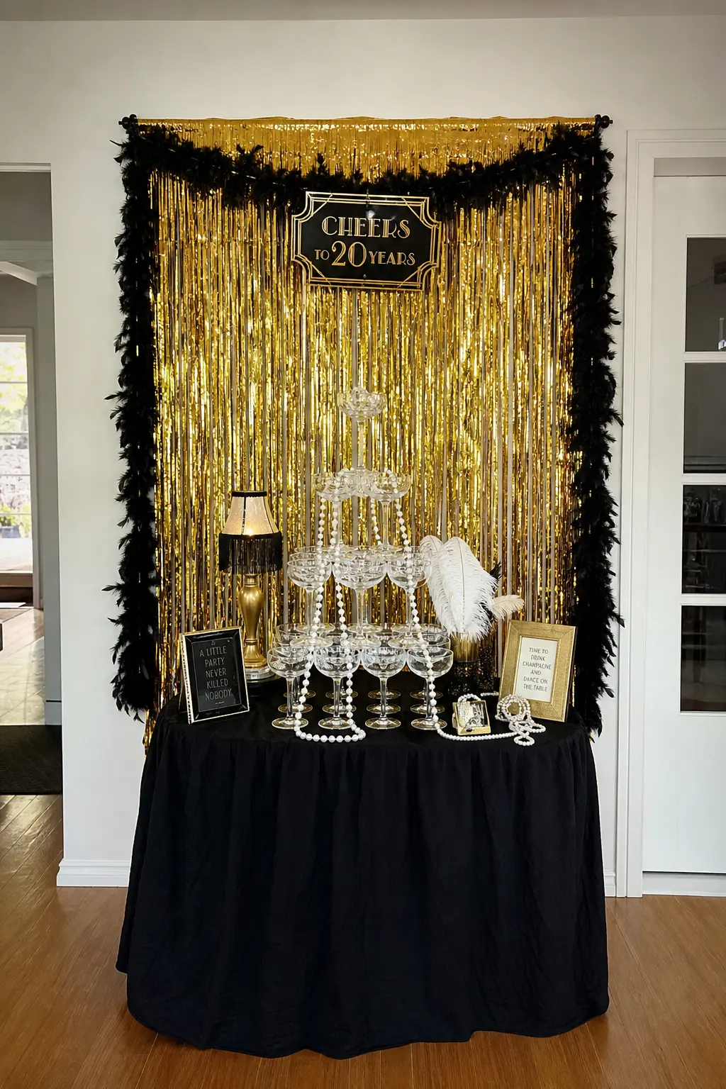 Roaring Twenties Speakeasy — A champagne coupe tower is the centerpiece, styled in gold and ivory against a fringe backdrop, with pearls draped over the base
