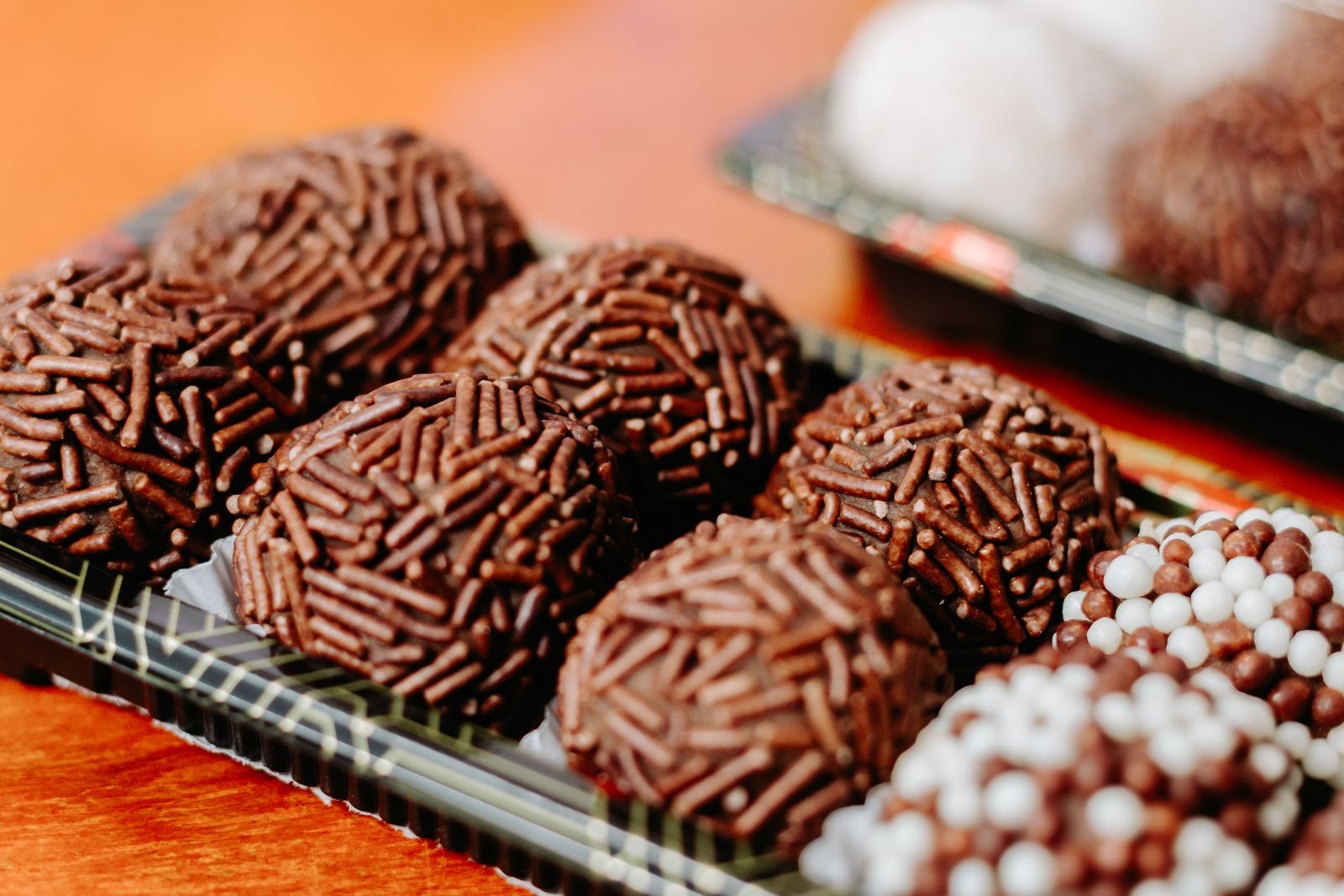 Close-up of delicious chocolate brigadeiros adorned with sprinkles, perfect for celebrations and parties.
