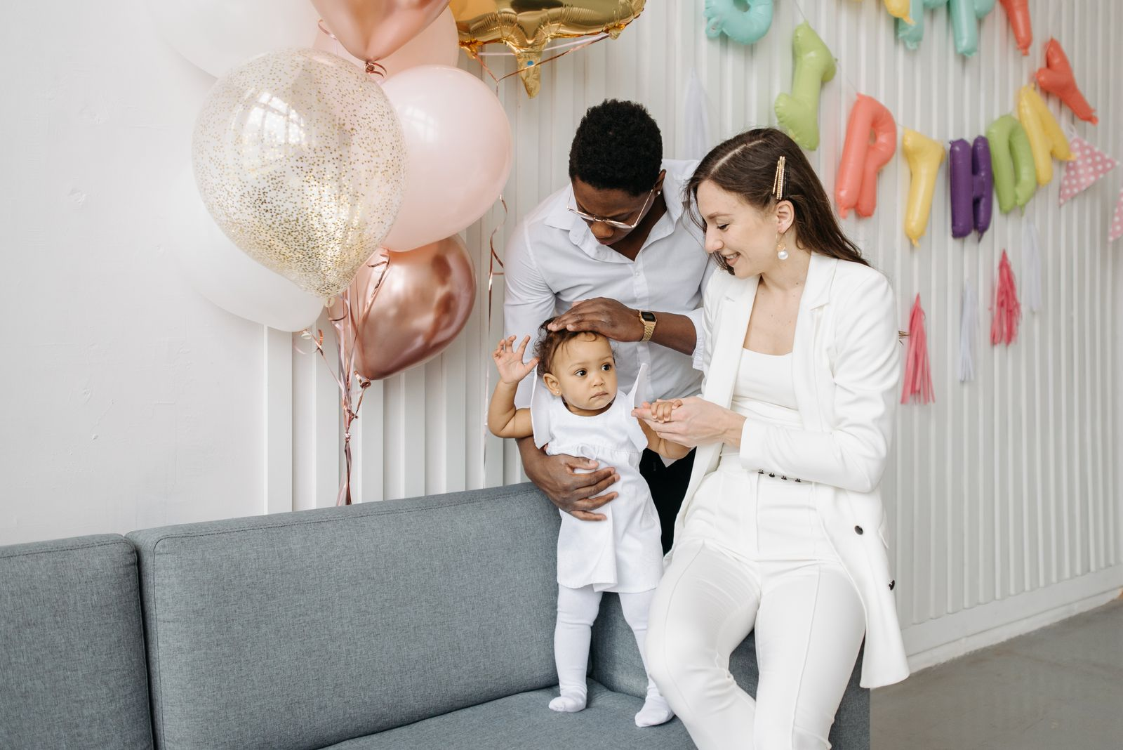 A joyful family celebrating a birthday indoors with balloons and smiles.