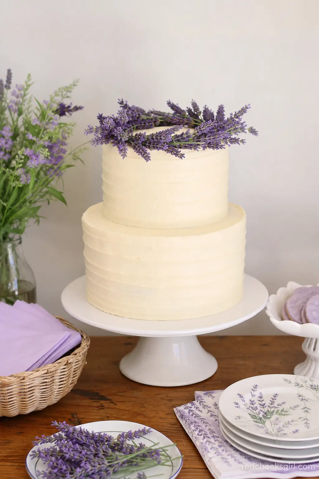 Lavender and Ivory Flower Crowned Cake — A two tier ivory buttercream cake topped with a loose crown of fresh lavender stems and a few trailing sprigs down one