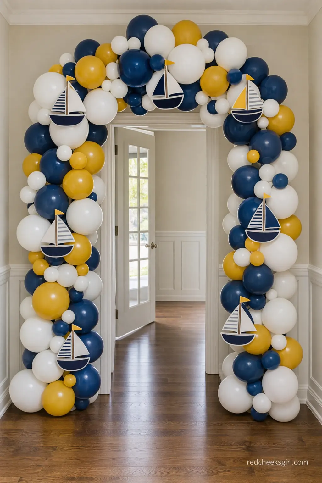 Little Sailboat Balloon Arch — A balloon arch in navy, white and mustard turns a plain doorway into a proper entrance without any carpentry. Baby on board baby
