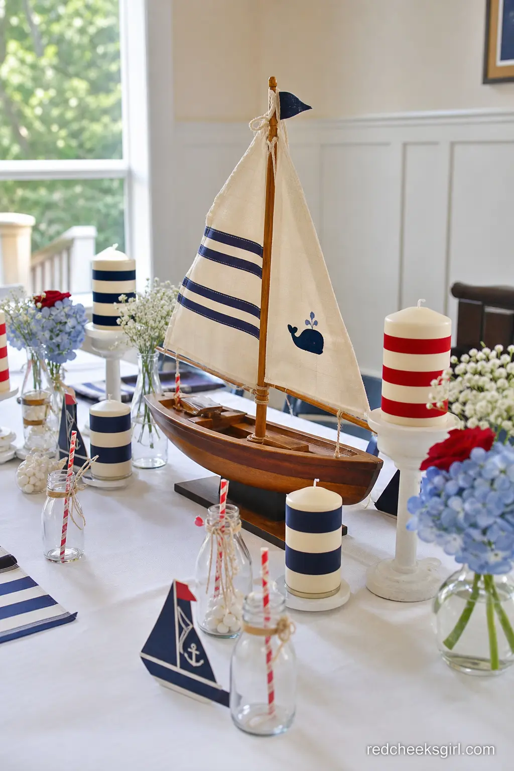 Sailboat Centerpiece Table — For a sit-down shower, a wooden sailboat centerpiece flanked by striped taper candles does the job a floral arrangement usually