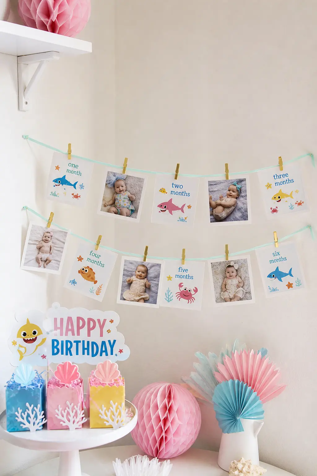 Polaroid Milestone Garland Corner — A length of mint ribbon strung corner to corner, hung with instant photos from every month of her first year using tiny