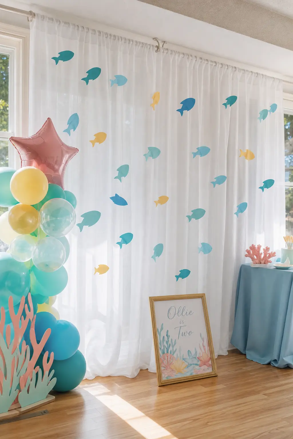 Sheer Under-the-Sea Photo Wall — White sheer curtain panels, dotted with a few paper fish in aqua and yellow, make a photo backdrop soft enough to actually