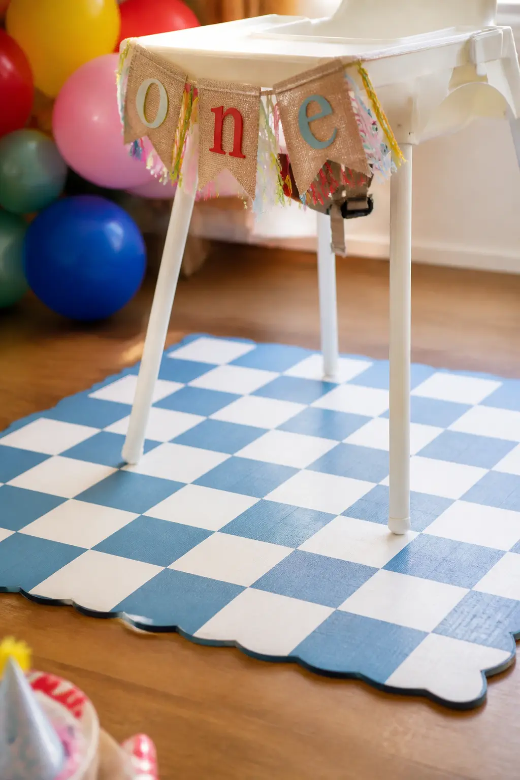 Chequered Floor Mat Under the High Chair — Place a vinyl chequered mat, in white and one accent colour such as blue or pale yellow, directly under the high