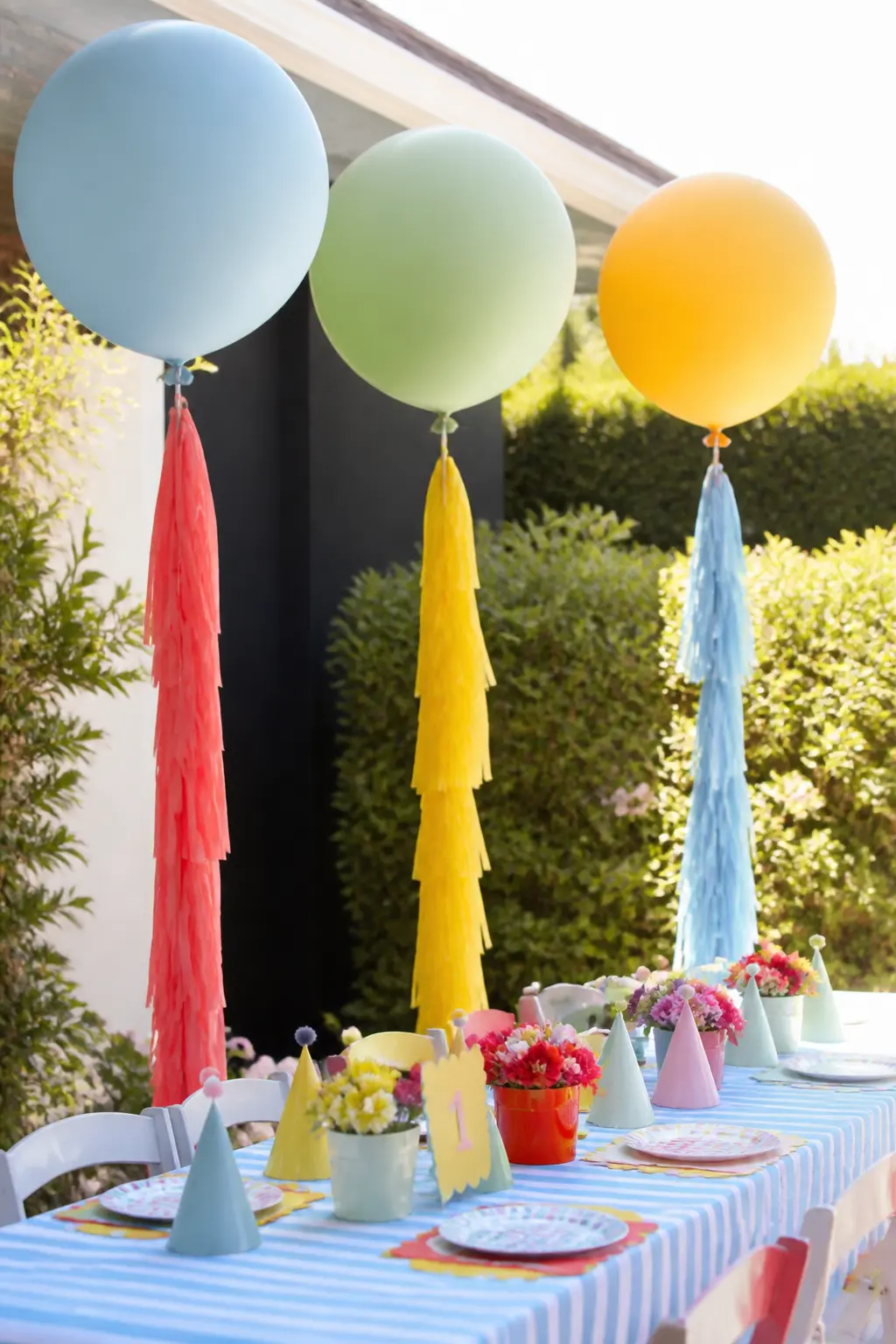 Giant Round Balloon Centrepieces with Tissue Tassels — Fill 36-inch latex balloons with helium and tie a long tissue-paper tassel to each one in a contrasting