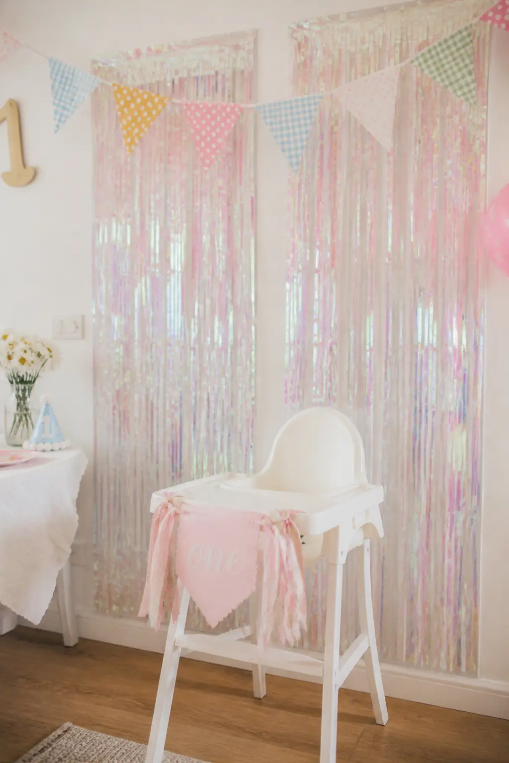 Iridescent Fringe Curtain Backdrop — Two panels of iridescent tinsel fringe curtain, hung side by side against a wall, create a backdrop that catches every