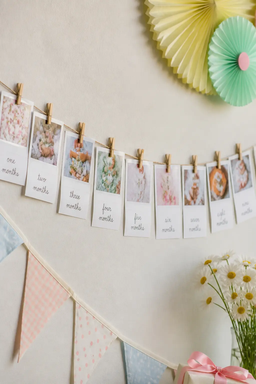 Monthly Milestone Photo Banner — Twelve small photographs, one from each month of the baby's first year, printed at four-by-four inches and hung with mini