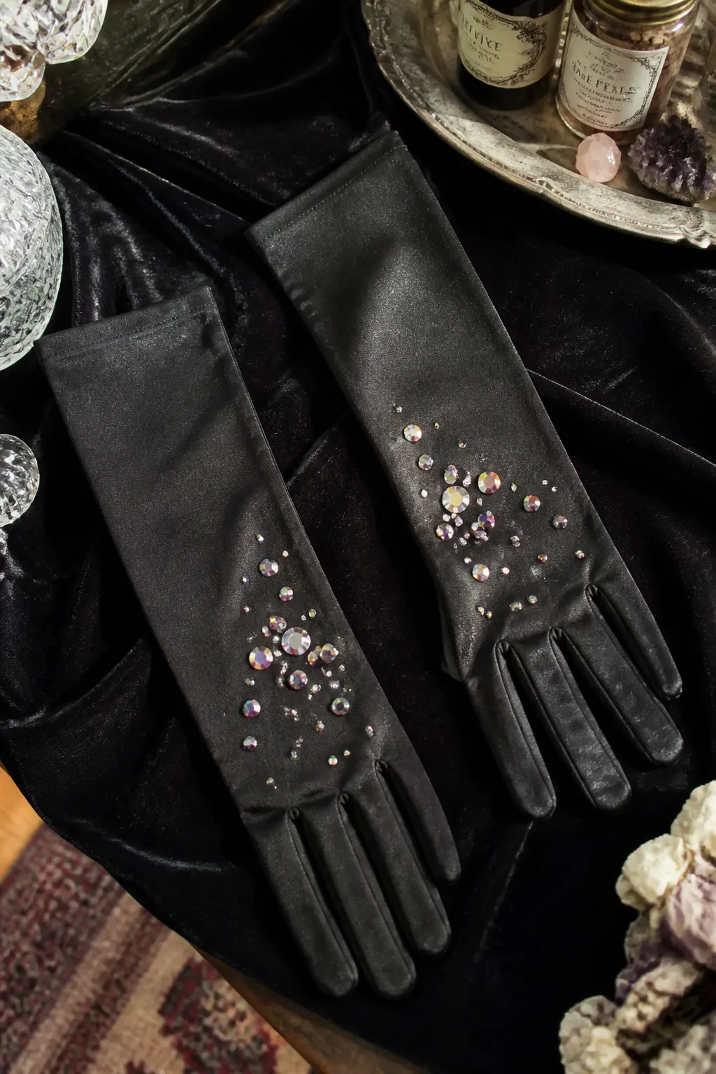 Crystal-Tipped Black Gloves — Long black satin or velvet opera gloves, the kind that reach the elbow, get a scattering of AB rhinestones on the back of the