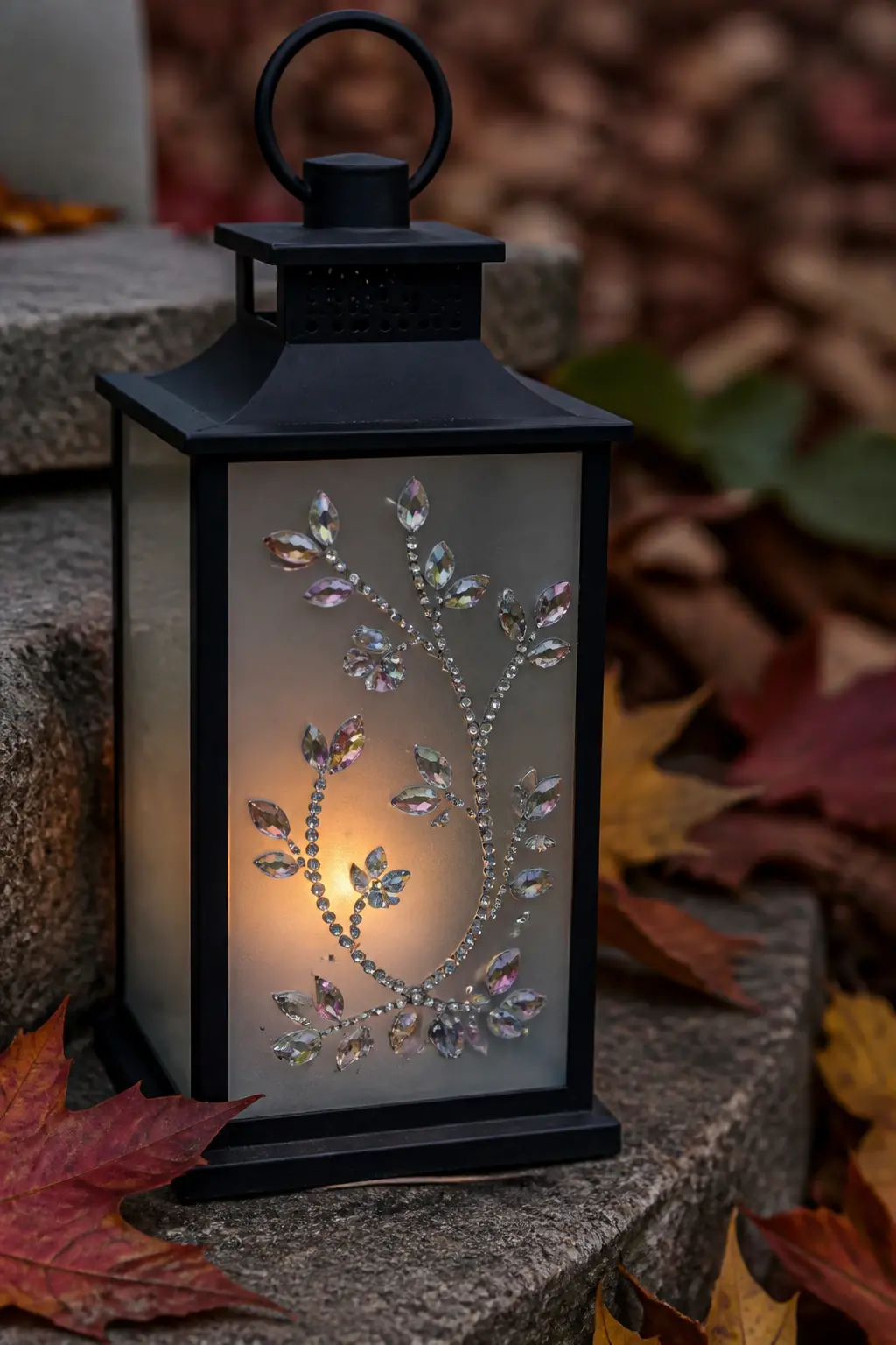 Frosted Lantern with Gem Vine — A metal or black wire lantern gets a trailing vine drawn across one panel in gem glue, then covered immediately in a mix of