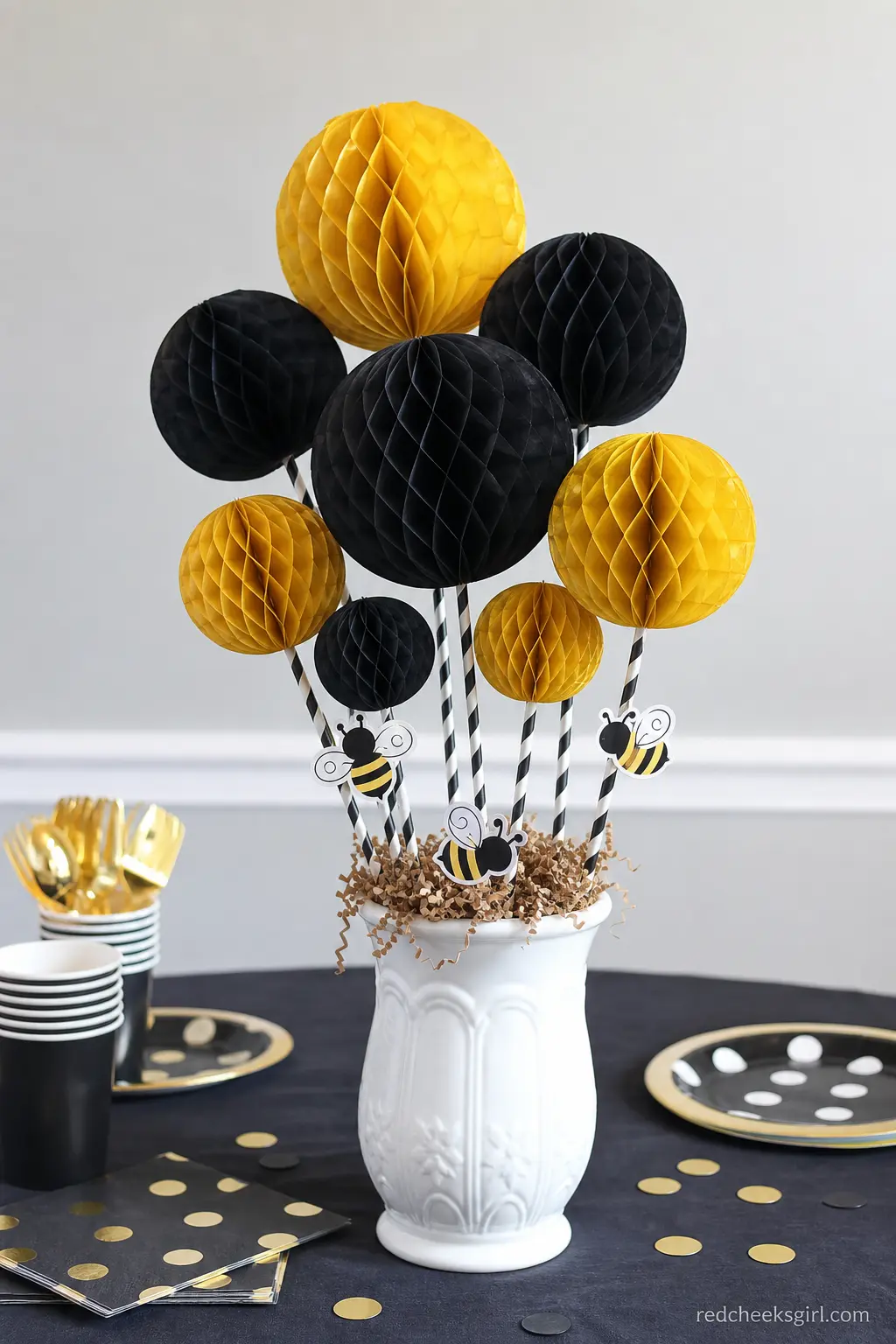 Black and Gold Honeycomb Pom Centerpiece — Tissue paper honeycomb balls give height without the fuss or cost of fresh flowers, and they pack flat afterward for