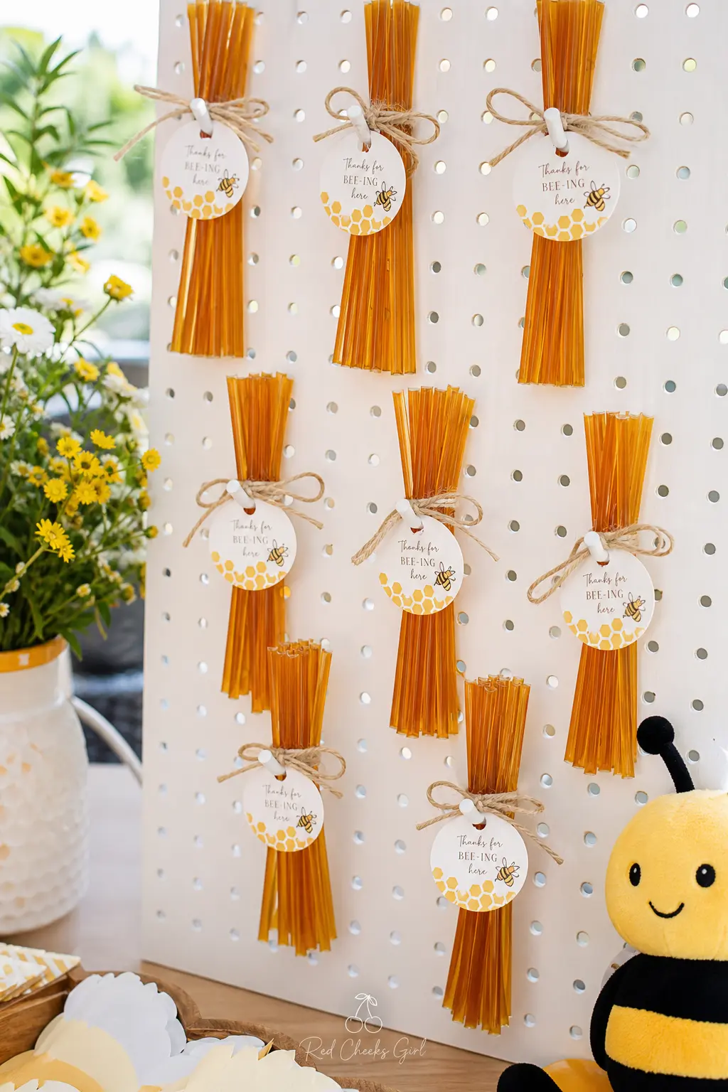 Honey Straw Favor Pegboard — Honey sticks hung in bundles turn a favor table into something worth photographing, and a pegboard near the exit means nobody