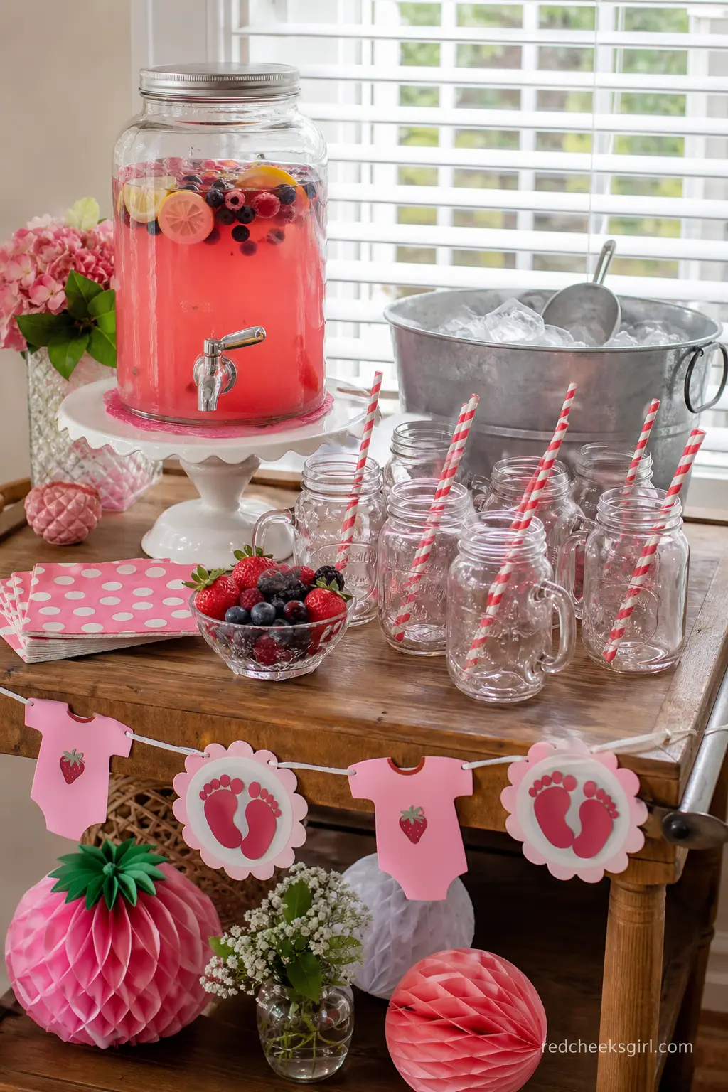 Berry Lemonade Mason Jar Bar — Roll a small bar cart into the corner and fill a glass dispenser with pink berry lemonade. Berry sweet baby shower theme
