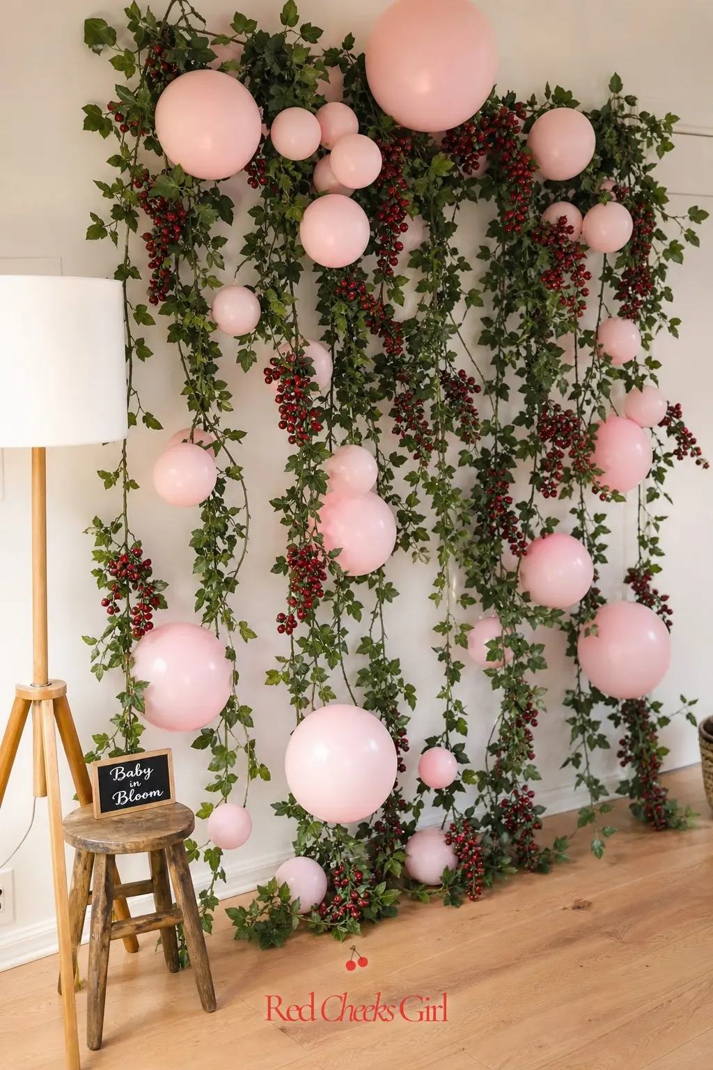Blush and Berry Vine Backdrop — A trailing vine garland studded with deep red berry clusters turns one wall into a photo spot without a single prop. Berry