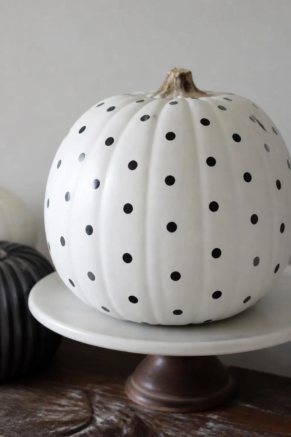 Even Polka Dots on White — Base coat in white, then use a round foam brush or a wine cork dipped in black paint to stamp evenly spaced circles across the