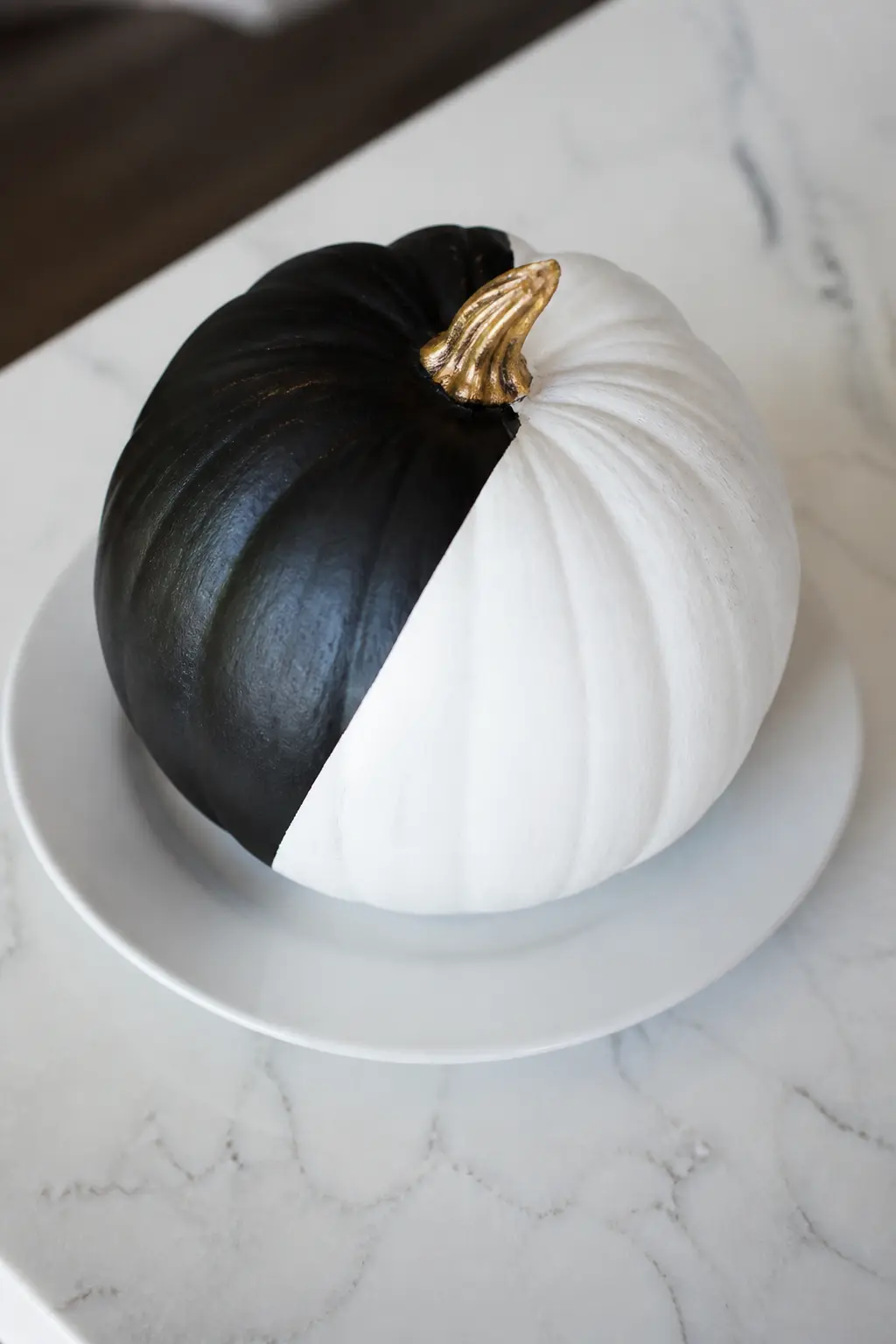 A Single Diagonal Split — Tape a single diagonal line from top left to bottom right across the entire pumpkin. Black and white painted pumpkin