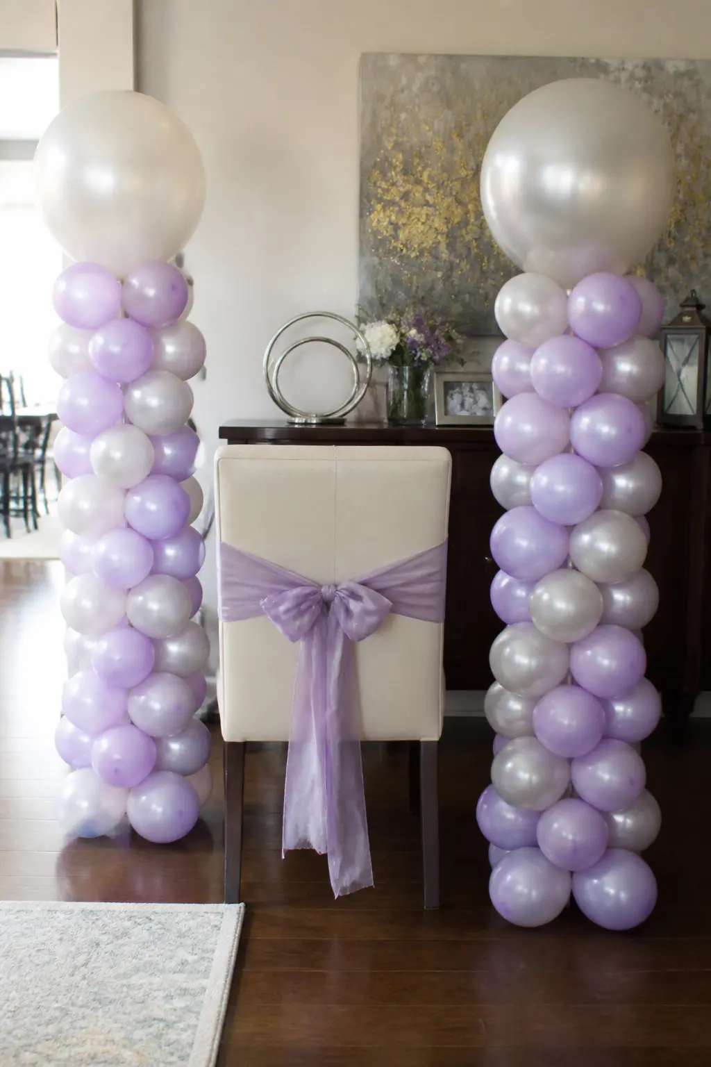 Lilac and Pearl Columns Either Side of the Bride's Chair — Two slim balloon columns in lilac and pearl stand on weighted bases either side of the bride's
