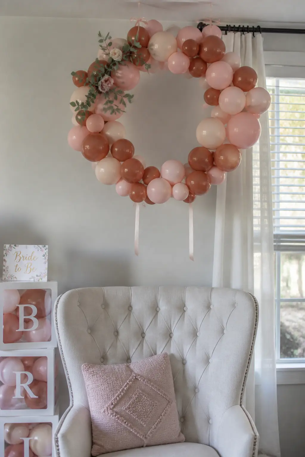 Terracotta and Blush Hoop Above the Sweetheart Chair — A hoop of terracotta and blush balloons hangs from the ceiling above the bride's single chair, sized so