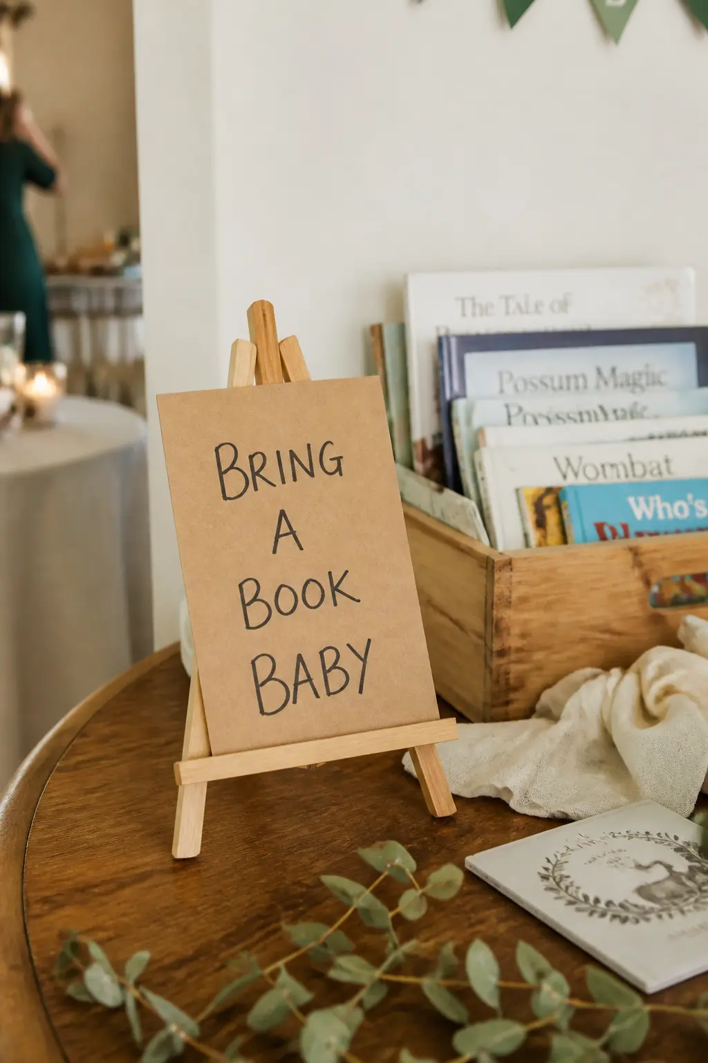 The Leaning Easel Sign — A small easel holding a kraft card sign does two jobs at once: it faces the door without anyone attaching anything to a wall, and it