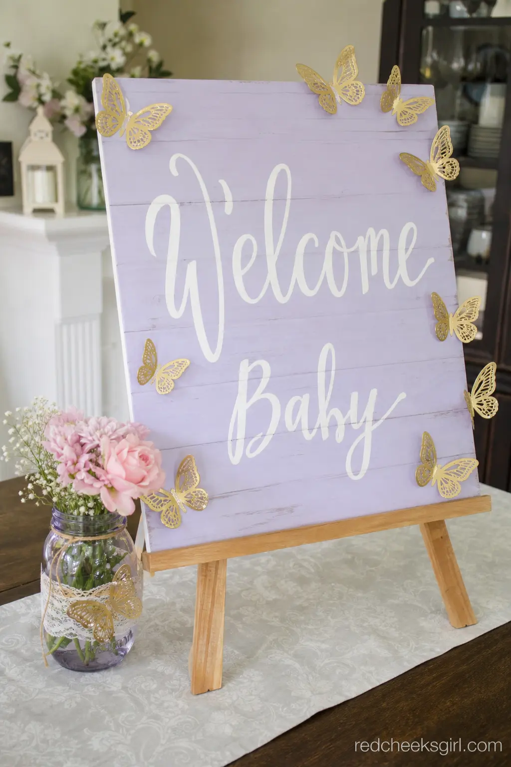 Floral Welcome Sign with Butterfly Cutouts — A single sign on an easel does the job of a whole backdrop for a fraction of the setup time. Butterfly baby shower