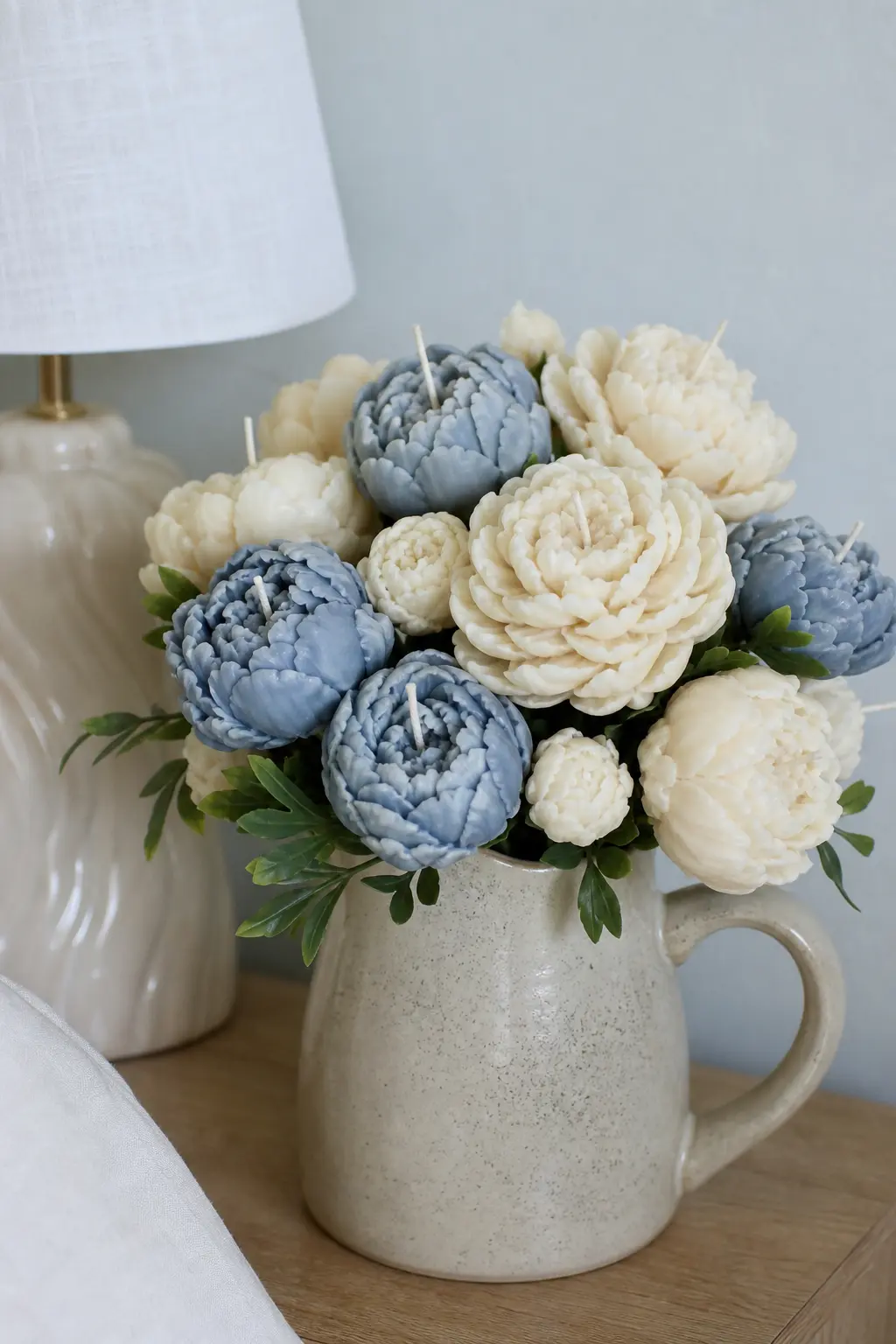 The Quiet Bloom — Peony-shaped candles in ivory and dusty blue, poured in beeswax rather than soy because the ruffled peony cavity is deep and beeswax holds