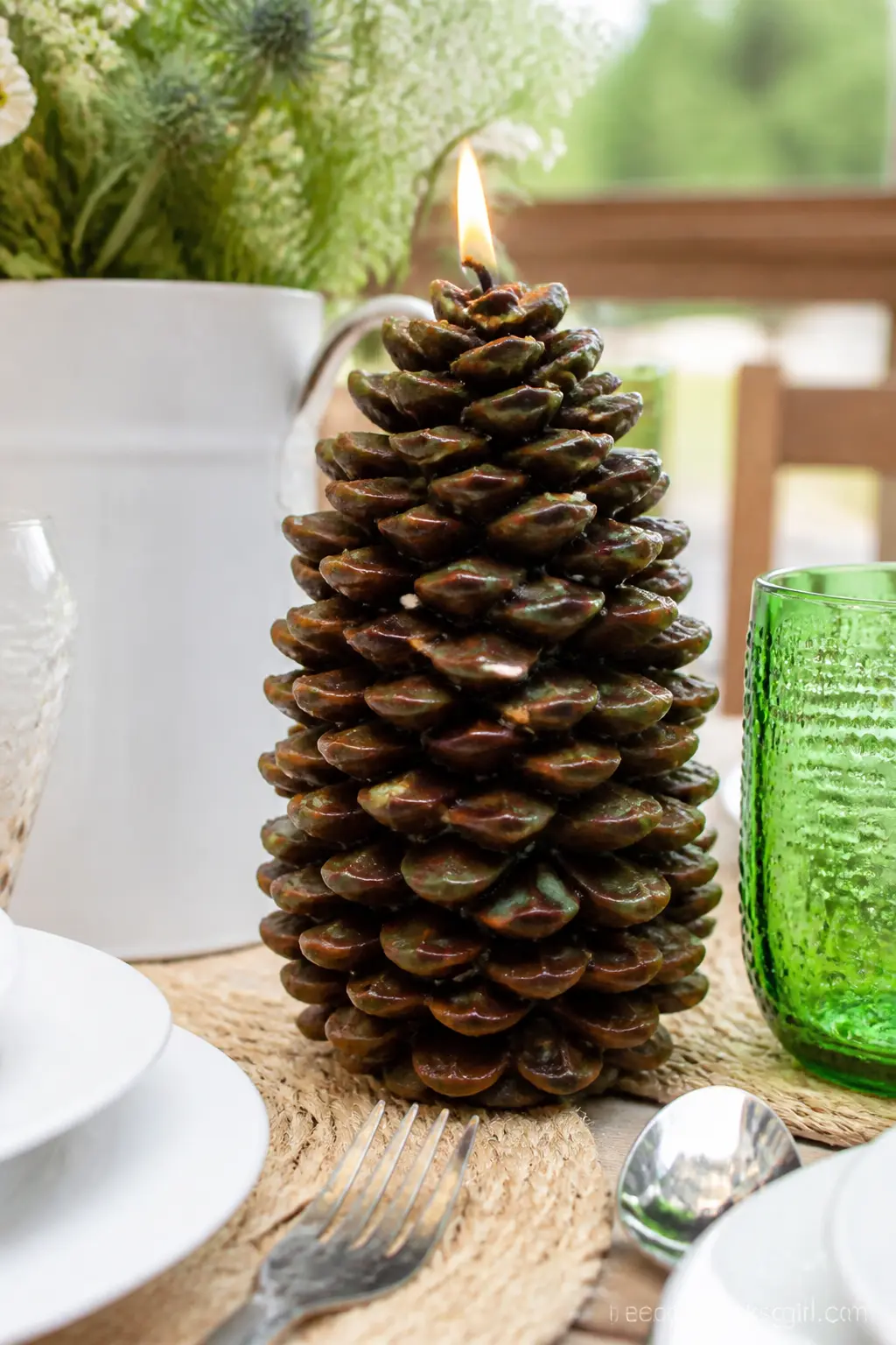 Pinecone Pillar Candle — A deep brown and olive pinecone candle, its scales textured with real definition, belongs on a mantel once the weather turns, with
